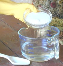 Pouring the lye into the distilled water.