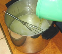 Pour olive oil into hot coconut and vegetable oils.